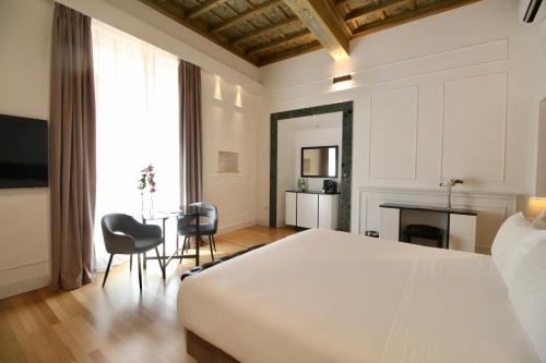 Un dormitorio con una cama y una mesa y sillas. en Palazzo Goldoni Condotti Collection, en Roma