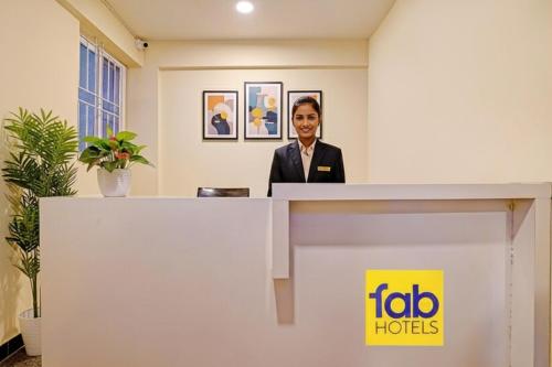 une femme debout derrière un comptoir d'accueil dans un bureau dans l'établissement FabHotel Platinum - Shivaji Nagar, Commercial Street, à Bangalore