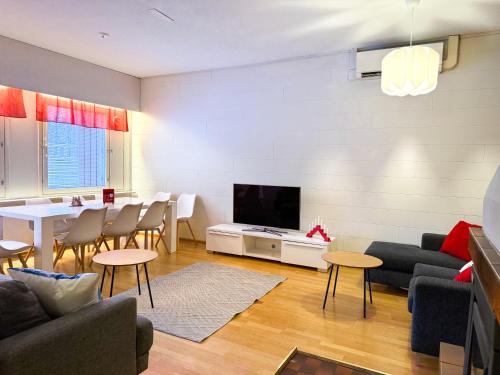a living room with a couch and a dining room at Large Group Fireside Cabin in Rovaniemi
