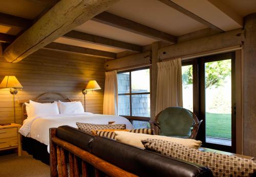 a bedroom with a bed and a couch and windows at Sun Mountain Lodge in Winthrop