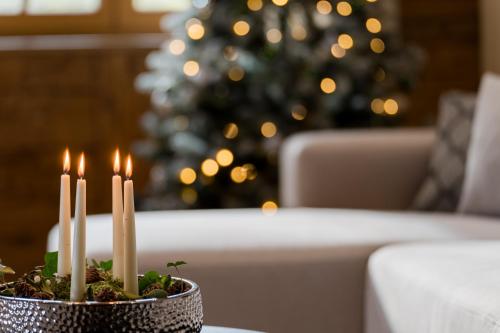 a group of candles on a table in front of a christmas tree at Arnestgut in Strobl