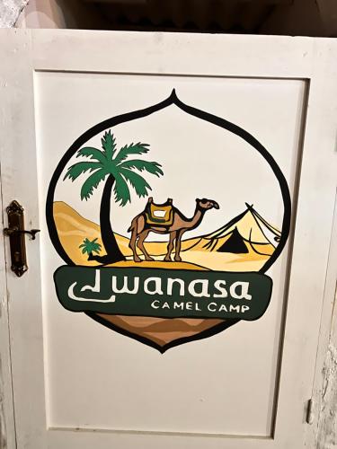 a sign on a door with a camel and a palm tree at Wanasa Camel in Dahab