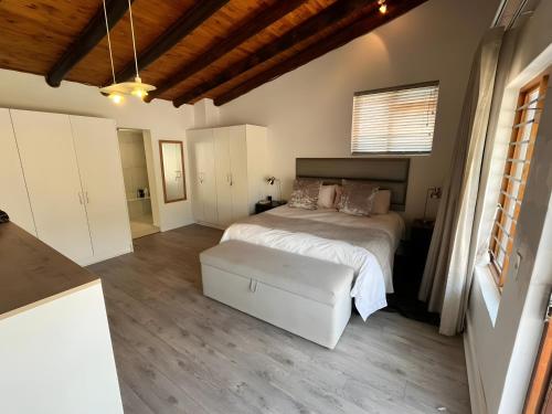 ein Schlafzimmer mit einem weißen Bett und einer Couch in der Unterkunft SeaSalt Escape in Plettenberg Bay