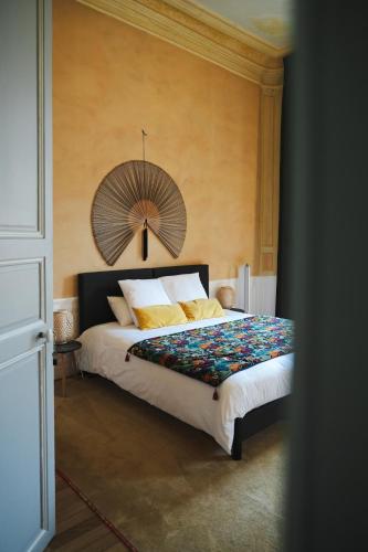 1 dormitorio con 1 cama grande y ventilador en la pared en Le Henri II - logements d'exceptions entièrement autonomes, en Le Mans