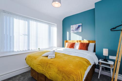 a bedroom with a large bed with a yellow blanket at Contractor Heaven Four Bedroom Free Parking in Manchester by Eason Stays in Little Hulton