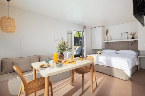 a bedroom with a bed and a table and a couch at Pinadria Adriatic Coast in Baška Voda