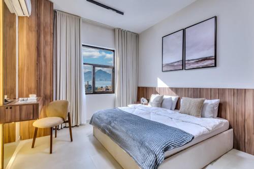 a bedroom with a large bed and a chair at 2BR and maidroom khorfakan Cornish 2 in Khor Fakkan