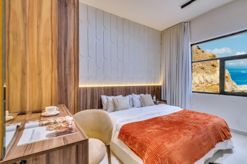 a bedroom with a bed and a desk and a window at 2BR and maidroom khorfakan Cornish 2 in Khor Fakkan