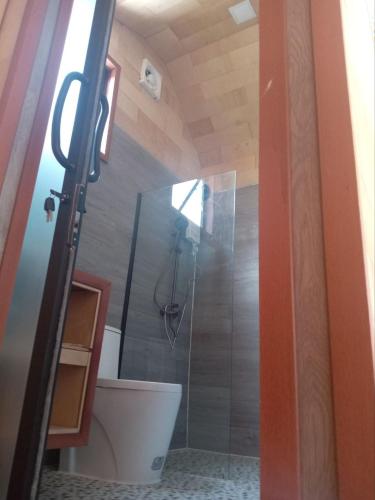 a bathroom with a shower with a toilet and a glass door at Royal C Beach Resort in Koh Rong Island