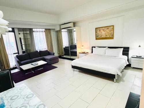 a large bedroom with a bed and a couch at Millennium Suites At Berjaya Times Square KL in Kuala Lumpur