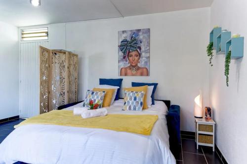 um quarto com uma cama grande e um cobertor amarelo em Appartement confortable à Sainte-Luce 50 m² avec terrasse em Sainte-Luce