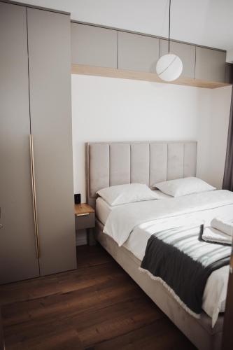 a bedroom with a large white bed and a closet at Apartman Monet in Pale