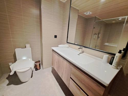 a bathroom with a toilet and a sink and a mirror at 丰居中壢 Via Hotel Zhongli in Zhongli