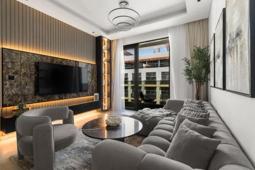 a living room with a couch and a table at Stylish 2 Bedrooms, Pool, Gym & Family-Friendly in Dubai