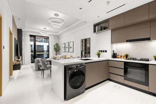 a kitchen with a washer and dryer in it at Stylish 2 Bedrooms, Pool, Gym & Family-Friendly in Dubai