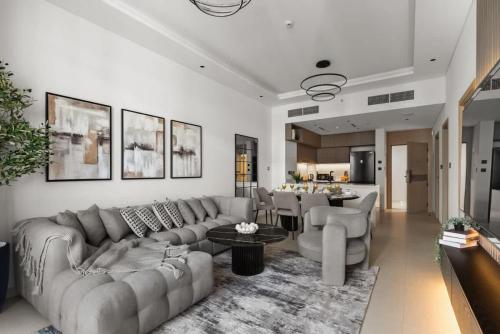 a living room with a couch and a table at Stylish 2 Bedrooms, Pool, Gym & Family-Friendly in Dubai