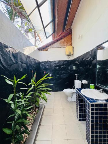 a bathroom with a sink and a toilet at Rumi Bumi Lovina - A Home For Unhurried Days in Lovina