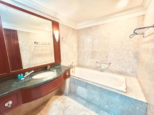 a bathroom with a sink and a bath tub at Millennium Suites At Berjaya Times Square KL in Kuala Lumpur