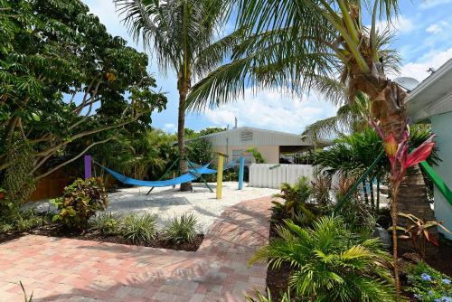 a hammock in a garden with palm trees at Siesta Key Palms Resort in Sarasota