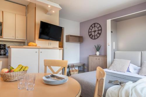 a living room with a table and a room with a bed at Résidence Pierre & Vacances La Promenade des Bains in Saint-Raphaël