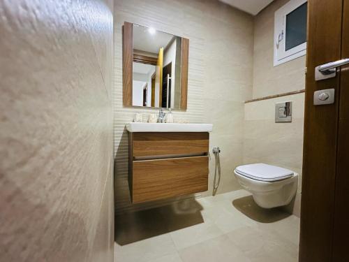 une salle de bain avec toilettes, lavabo et miroir dans l'établissement Safa, à Tunis