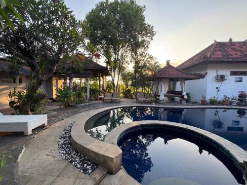 una piscina en un patio con una casa en Rumi Bumi - Lovina Rice Terrace Retreat, en Lovina