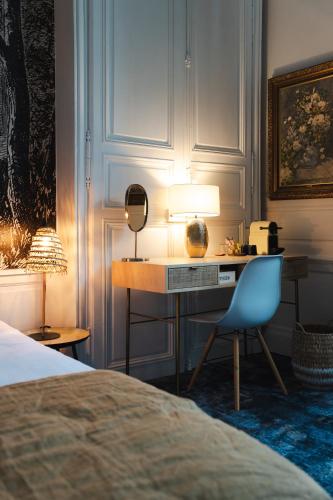 a bedroom with a desk with a lamp and a chair at Le Henri II - 15 min du circuit, arrivées & départs autonomes in Le Mans