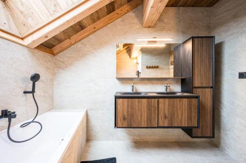 een badkamer met een wastafel en een ligbad bij Chalet l'Orée in Valloire