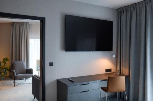 弗罗茨瓦夫加弗罗茨瓦夫Q酒店的酒店客房设有一张桌子和一台墙上的电视