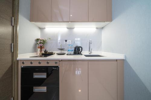 une cuisine blanche avec un évier et une cuisinière dans l'établissement Zun Xiang Executive Apartment - Shenzhen Futian Exhibition Center, à Shenzhen