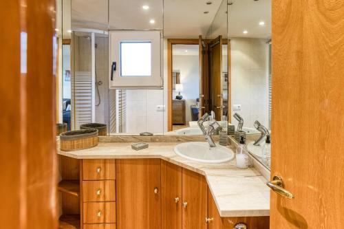 une salle de bain avec un lavabo et un grand miroir dans l'établissement Apartamento Rocio en Calella, à Calella de Palafrugell