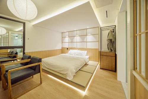 a bedroom with a bed and a desk and a chair at 컬리넌 호텔 앤 스파 in Seoul