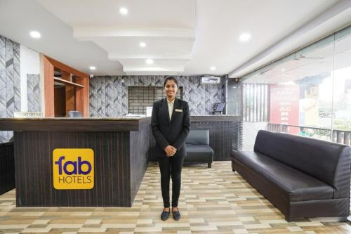 una mujer parada frente al vestíbulo de un hotel en FabHotel Millennium Suites - Millennium Plaza, Hosur Road, opp Vimalalaya Hospital, en Bangalore