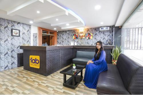 una mujer sentada en el vestíbulo de un hotel en FabHotel Millennium Suites - Millennium Plaza, Hosur Road, opp Vimalalaya Hospital, en Bangalore