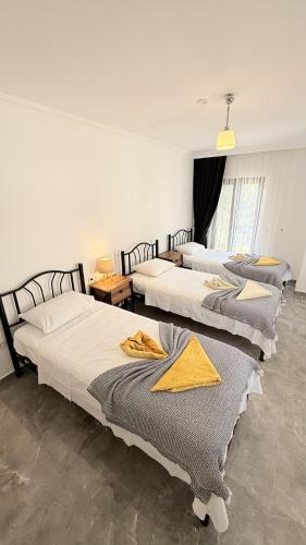 a group of three beds in a room at Villa Kaan in Ortaca