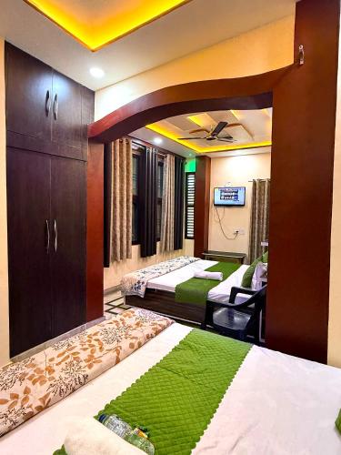 a room with two beds in it with green carpet at Guru Amrit Residency & Guru Kripa Guest house in Ayodhya