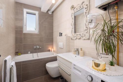 ein Badezimmer mit Toilette, Badewanne und Waschbecken in der Unterkunft Villa Fani in Supetar