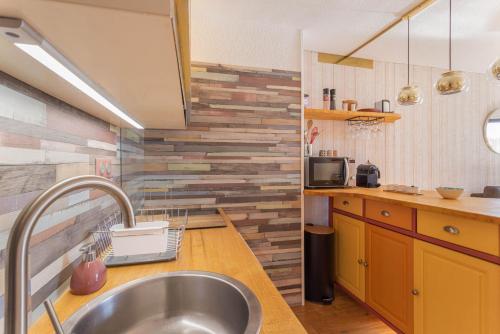 a kitchen with a stainless steel sink and wooden counters at Les Mille Et Une Voiles Appart T2 in Port Leucate
