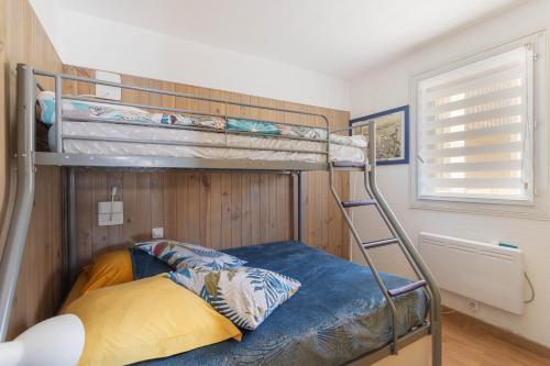 a bedroom with a bunk bed with a blue bed at Les Mille Et Une Voiles Appart T2 in Port Leucate