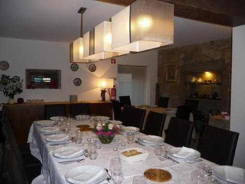 a long table with white plates and glasses on it at Casa Dos Poços in Vilar Torpim
