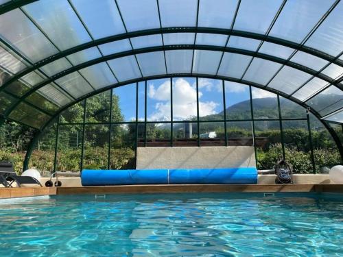 a swimming pool with a glass domed ceiling and an indoor swimming pool at Camping 3 étoiles - Piscine - eehhec in Landry