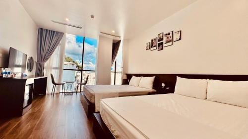 a hotel room with two beds and a table at Cát Bà Swiss Hotel in Cat Ba