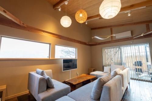 a living room with couches and a tv and a table at Dannoura Resort Villa in Takamatsu