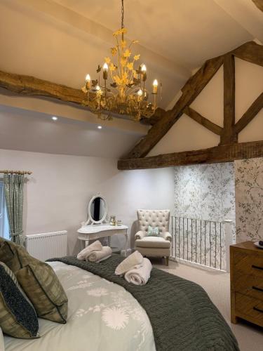 a bedroom with a large bed and a chandelier at The Hayloft our perfect countryside retreat in Stoney Middleton