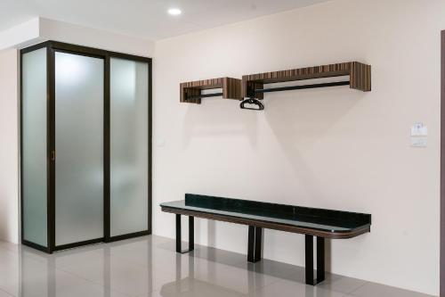 un banc dans une pièce avec un mur et une étagère dans l'établissement One Budget Hotel Chiangrai Bypass-West, à Ban Hua Khwai (1)