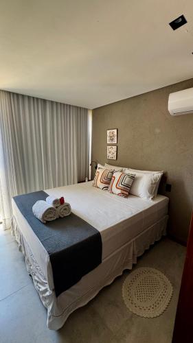 a bedroom with a large bed with pillows on it at Patacho Brisa Mar - Triplex na Rota Ecológica dos Milagres in Pôrto de Pedras
