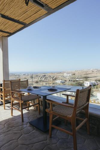 een tafel en stoelen op een terras met uitzicht bij Evi Suites & Villas in Mykonos-stad