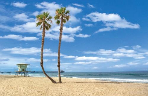 twee palmbomen op een strand met een reddingstoren bij 5N-31 Beach View BBQ & Jacuzzi in Oceanside