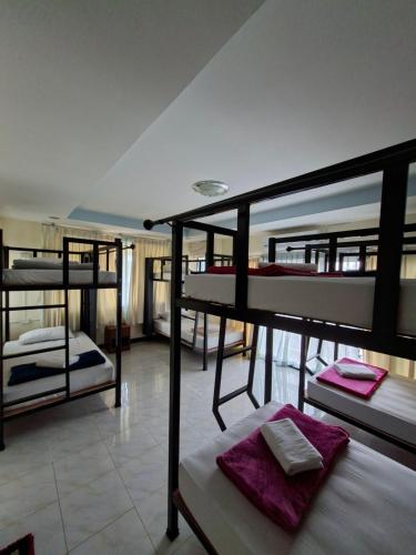 a room with three bunk beds with purple towels at Cocoloco hostel in Ban Khlong Haeng