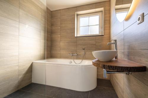 a bathroom with a white sink and a tub at Villa Linde | 4 personen - Vakantiepark De Kremmer in Gasselte